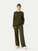 Person wearing an olive green outfit on a white background #color_capulet-olive