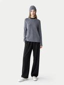 Person wearing a gray sweater and black pants on a white background #color_steel-gray