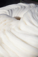 A coil of clean white cashmere sliver, conditioned and ready for spinning