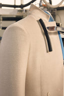 A cream cashmere coat on a form at a finishing station during final inspection