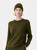 Person wearing an olive green sweater and beanie on a white background #color_capulet-olive