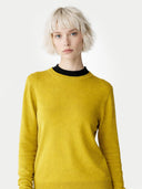 Woman wearing a yellow sweater with a plain background #color_biscay-bay