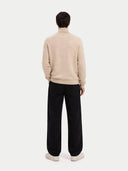 back view of a man wearing a beige sweater and black pants on a white background. #color_beige #ai-image