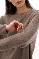 Close-up of a taupe seamless cashmere sweater showing its uninterrupted knit