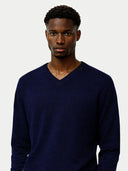 Man wearing a navy blue sweater against a plain background