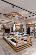 Inside a GOBI store: a wooden display table with folded knitwear under a round timber chandelier