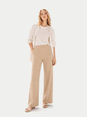 Woman wearing a white top and beige pants with a light beige cardigan on a white background. #color_beige #ai-image