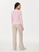 back view of a woman wearing a soft pink sweater and beige pants. #color_pink 